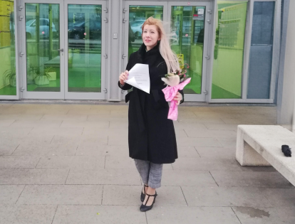 Helena Zrinski ispred poslovne zgrade, s mapom i cvijećem u rukama